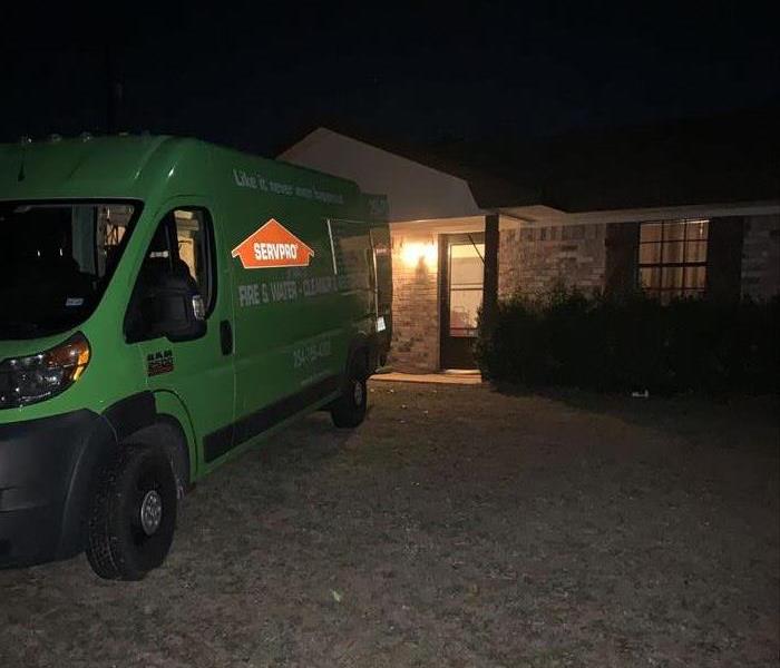 Van backed up in yard to a country home front door late at night.