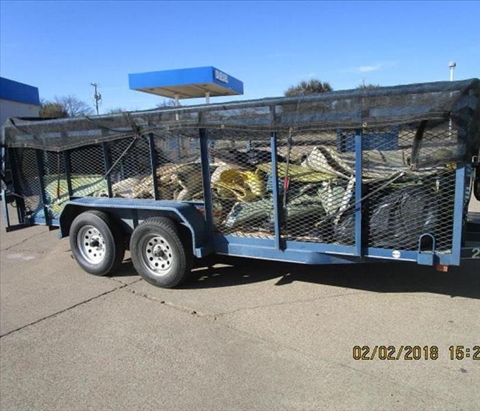 A wire sided trailer with debris removed from a water pie freeze damaged building