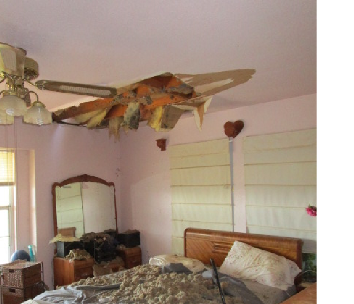 Ceiling section collapased onto a bed