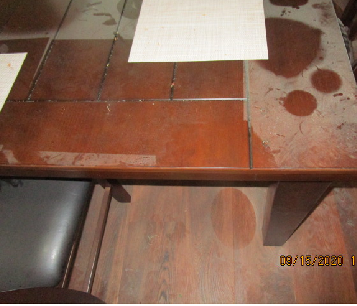 Kitchen table and chair covered in white powder except where items were covering areas of the table
