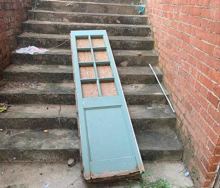 Old door side window panel laying on the stairs