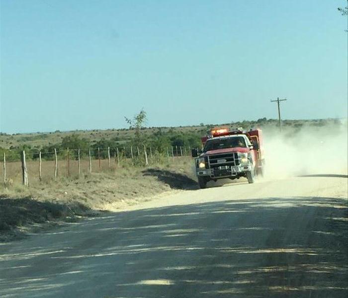 Fire truck speeding along a gravel road.