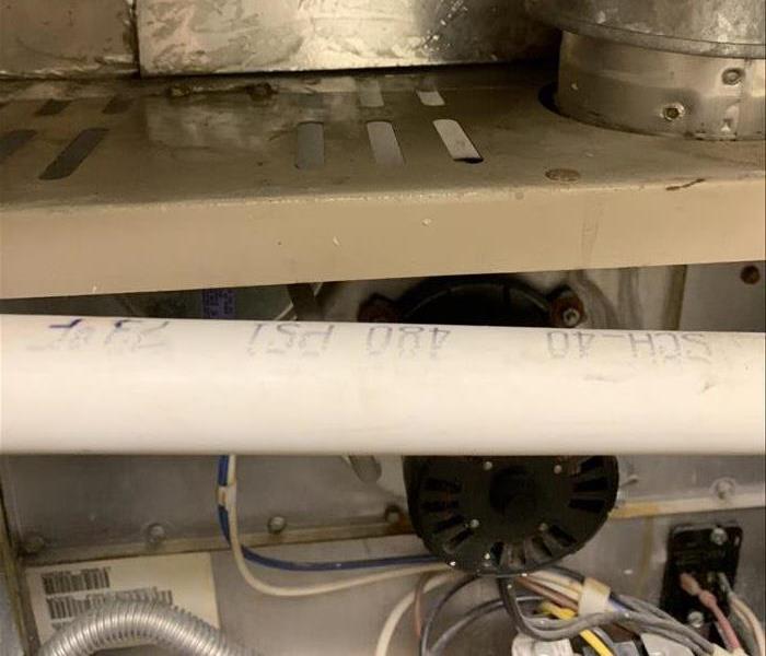 Photo of the top of a furnace (air handler) with water running from the top duct, out and down into the control areas of the 