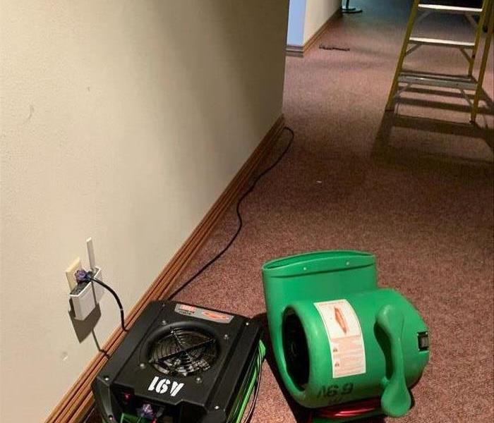 Two air movers placed for drying water damage in a church.  One is number A 91
