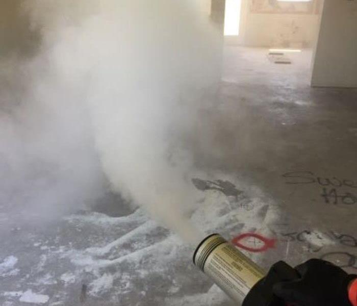 Picture is of a thermal fog machine producing fragranced white smoke into the air inside a home.