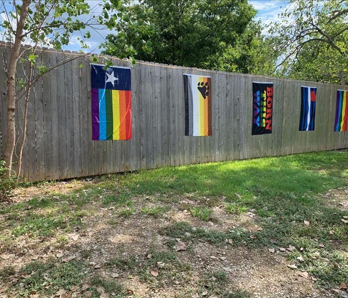 Rainbow/Pride flags on a wood fence